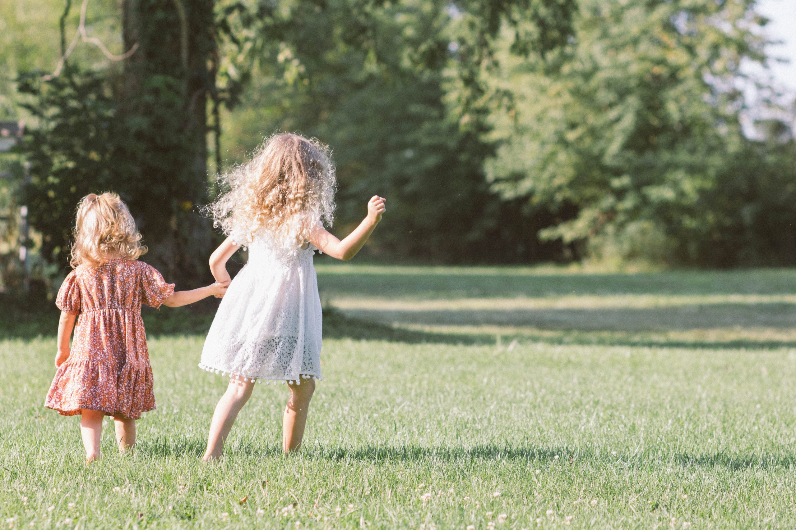 Two girls running on the grass.